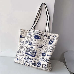 Detail of canvas tote bag featuring navy blue music-themed illustrations and twin handles