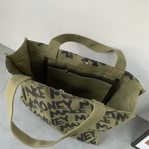 Detailed interior of green canvas tote with MAKE MONEY print and zipper pocket