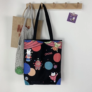 Detail der schwarzen Zirkus-Stofftasche mit Cartoon-Prints an einem Wandhaken