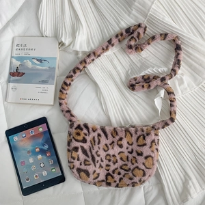 Detailed view of pink leopard print plush crossbody bag on a soft white background