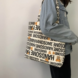 Detailed side view of large canvas tote bag with handsome bear print on model