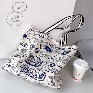 Detail of white canvas tote bag with blue retro graffiti and durable striped web handles