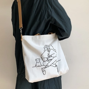 Detail of canvas tote bag featuring minimalist girl and dog illustration with brown strap