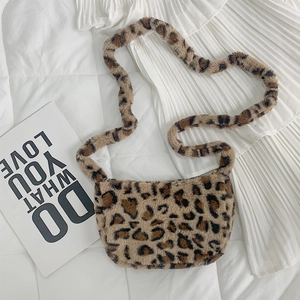 Detail of soft leopard print faux fur crossbody bag on a white cozy home setting
