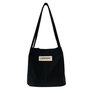 Minimalist black nylon tote bag with LADIESDAY patch and black fabric shoulder straps