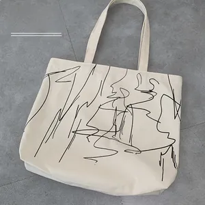 Detail of a large off-white canvas tote bag featuring minimalist black line art print
