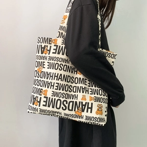 Detail of large canvas tote bag showing Handsome text and orange bear print