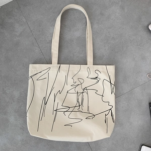 Top view of large cream canvas tote bag with black abstract art line printing