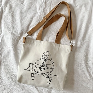 Macro shot of minimalist canvas tote with girl and dog illustration and brown strap