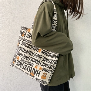 Detail of canvas tote bag featuring handsome lettering and cute bear print with hoody