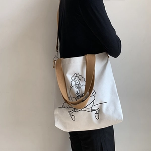 Detail of white canvas tote bag featuring an artistic girl drinking coffee line drawing