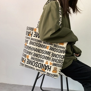 Detailed view of canvas tote bag with handsome lettering and orange cartoon bear print