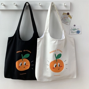 Dettaglio di borse tote in tela con simpatiche arance cartoon e testo Happy Oranges