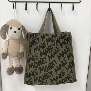 Detail of army green canvas tote bag featuring black MAKE MONEY printed lettering