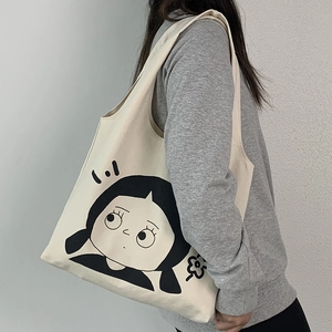 Detailansicht der cremefarbenen Canvas-Tasche mit süßer schwarzer Cartoon-Mädchen-Grafik