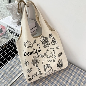 Dettaglio della borsa tote in tela bianco sporco con motivi artistici fatti a mano