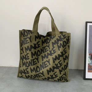 Detailed view of an olive green canvas tote bag featuring a repeating MAKE MONEY print