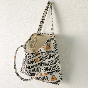 Detail of canvas tote bag with Handsome text and orange cartoon bear print