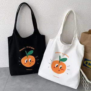 Dettaglio di borse tote in tela con stampa arancione cartoon e testo Happy Oranges
