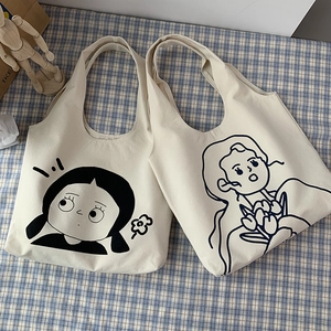 Detailansicht von Segeltuchtaschen mit Cartoon-Drucken und breiten Griffen auf Karomuster