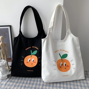 Dettaglio di borse tote in tela bianche e nere con stampe artistiche di arance