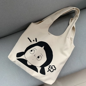 Detail eines niedlichen Cartoon-Mädchen-Prints auf einem cremefarbenen Canvas-Shopper