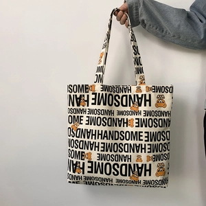 Detail of canvas tote bag featuring handsome lettering and orange cartoon bear prints