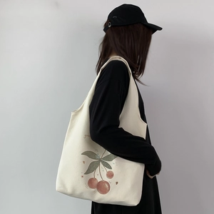 Minimalist canvas tote bag with cherry print and green text, casual student style