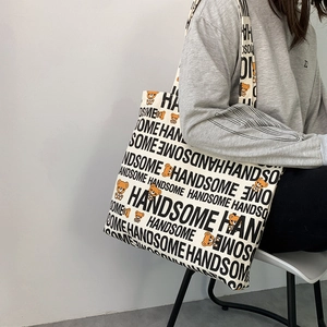 Detail of canvas tote bag featuring handsome lettering and cute cartoon bear patterns