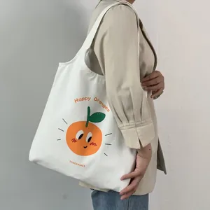 Dettaglio della grande borsa tote in tela bianca con stampa di arance e scritte