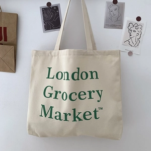 Detail of canvas tote bag featuring green London Grocery Market text and minimalist design