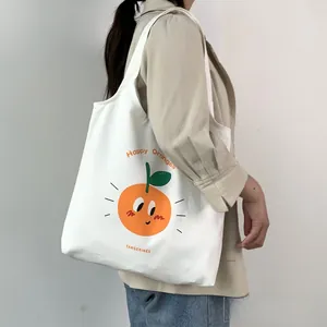 Dettaglio della borsa tote in tela bianca con stampe di arance e scritte vivaci