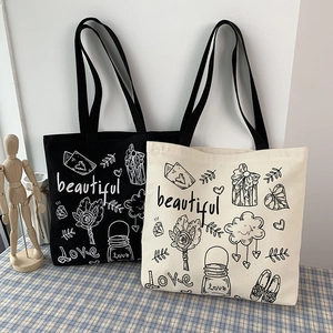 Dettaglio di borse tote minimaliste in tela nera e beige con stampe floreali d'arte