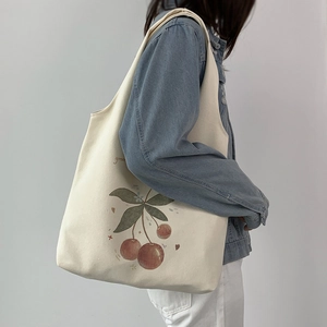 Minimalist beige canvas tote bag with cherry print and wide shoulder strap