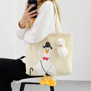 Detail of canvas tote bag with cartoon duck print, plush feet and alpaca charm