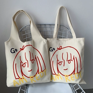 Detail of artistic canvas tote bags with red girl illustration on blue mesh chair