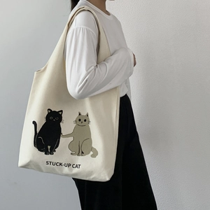 Detail of creative cartoon cat print on a large capacity cream canvas shoulder bag