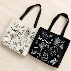 Dettaglio di borse tote in tela con arte floreale fatta a mano e scritte artistiche