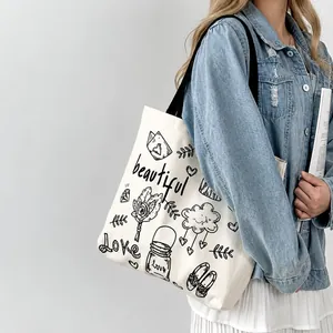 Dettaglio borsa tote in tela bianca con disegni floreali fatti a mano e testo Love