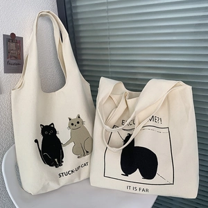 Close-up of cute cat illustrations and English text on thick cream canvas tote bags