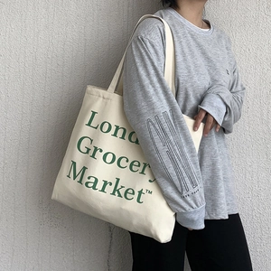 Close-up of cream canvas tote bag with green London Grocery Market print