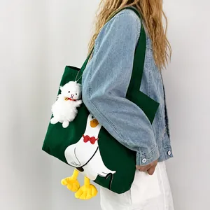 Detail of dark green canvas tote with cartoon goose print and cute yellow 3D feet