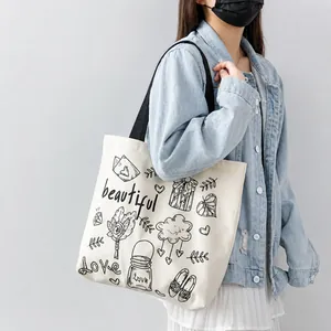 Dettaglio dei motivi di nuvole e cuori fatti a mano sulla borsa tote in tela bianca