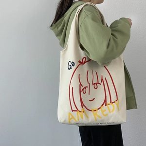 Detail of artistic canvas tote bag featuring red cartoon girl print and motivational text