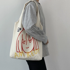 Detail view of the durable canvas tote bag featuring artistic cartoon graphic print