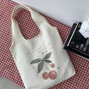 Close-up of minimalist canvas tote bag featuring hand-drawn cherry graphic and wide straps