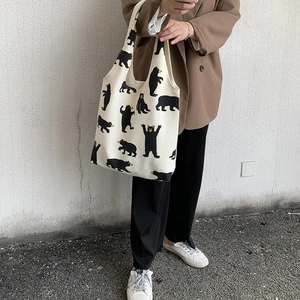 Detail of canvas tote bag with black cartoon bear patterns and sturdy handles
