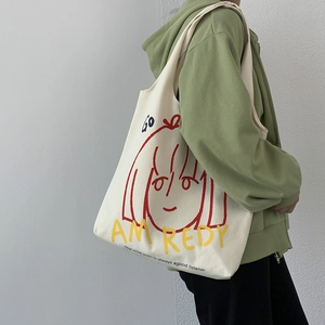 Close-up of minimalist tote bag featuring an artistic girl portrait and vibrant typography