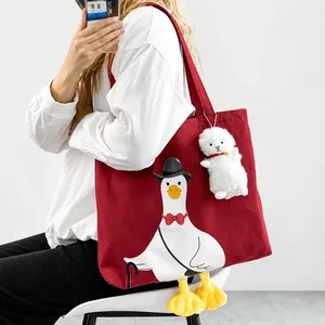 Close-up of cute cartoon duck canvas tote bag with 3D yellow plush feet and white lamb charm