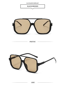 Detail of square double-bridge sunglasses with brown lenses and metal hinge accents